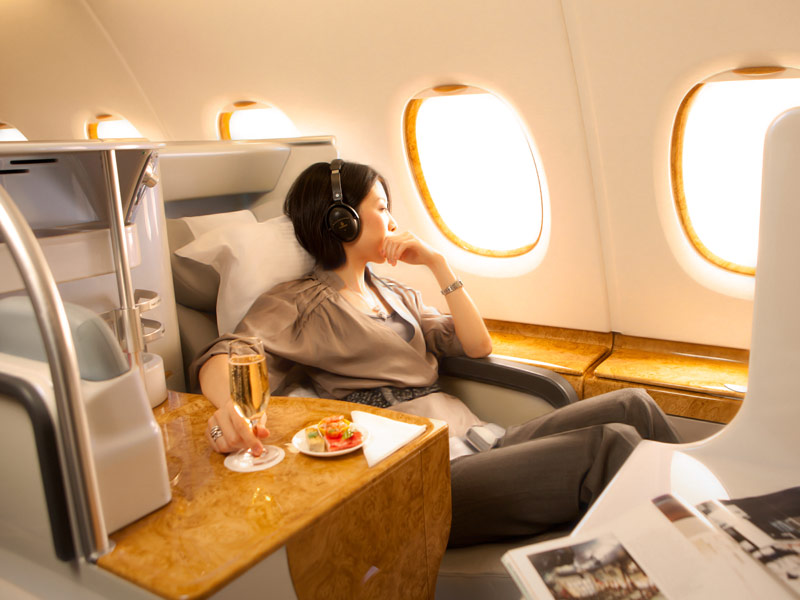 A woman looking out the window on a luxurious first-class flight.