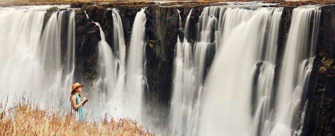 Traveler overlooking incredible waterfalls on a safari