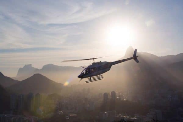 Silhouette of a helicopter flying above a city