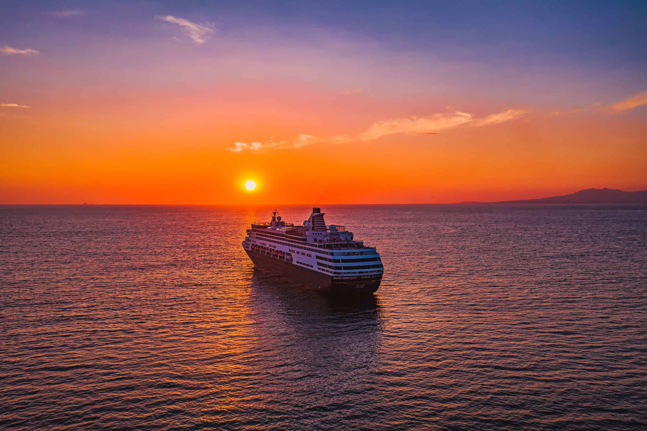 orange sunset in the background of a cruise ship on a voyage