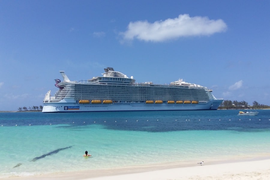 sandy teal water beach with cruise ship in distance