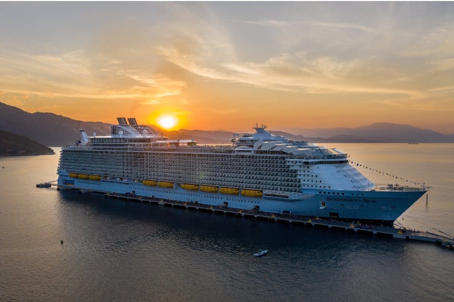 round sun shining in background of cruise ship at sea