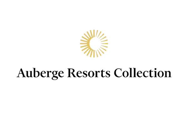 Logo of Auberge Resorts Collection, featuring a golden sun symbol above the brand name in elegant black font.